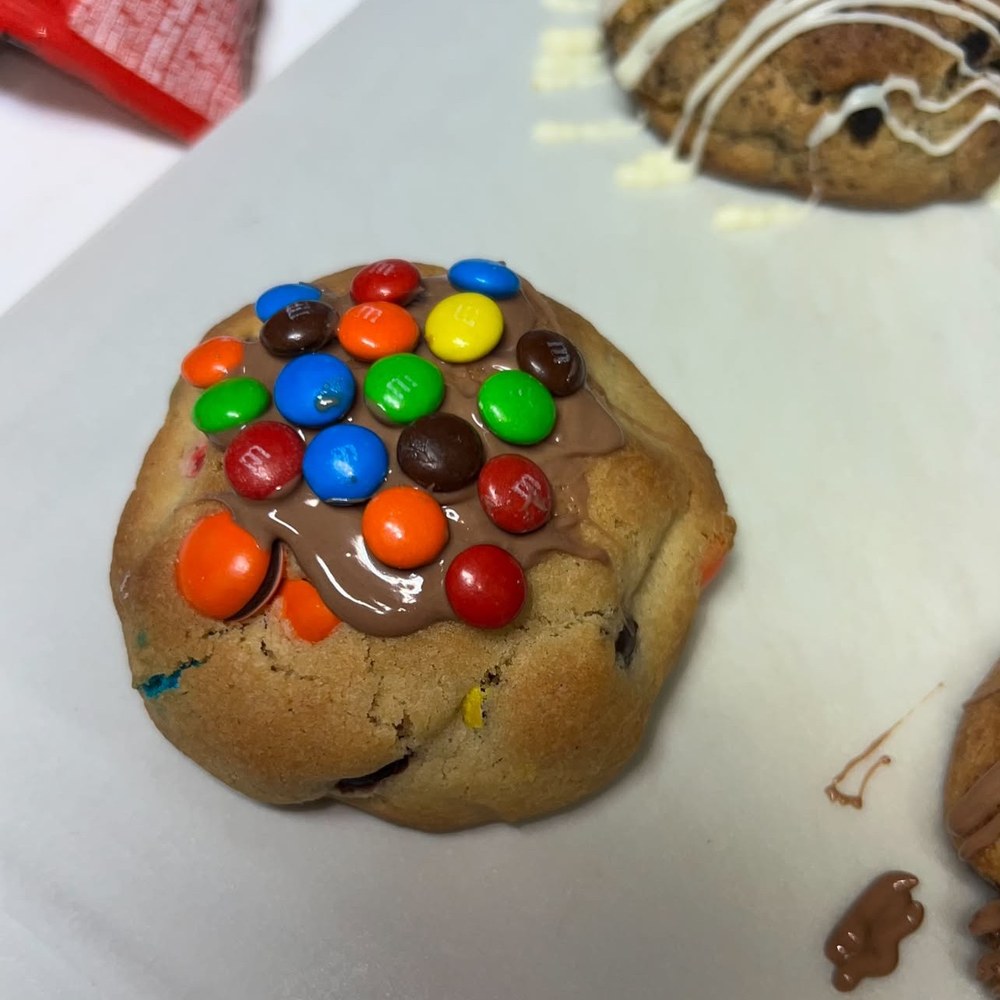 Loaded cookie topped with melted milk chocolate and colourful chocolate candies